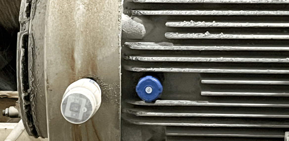 Close-up of an industrial machine from the Halo R4000 Series with a cylindrical metal surface, featuring a white and a blue knob. The machine health sensors show the surface appears dirty and corroded.