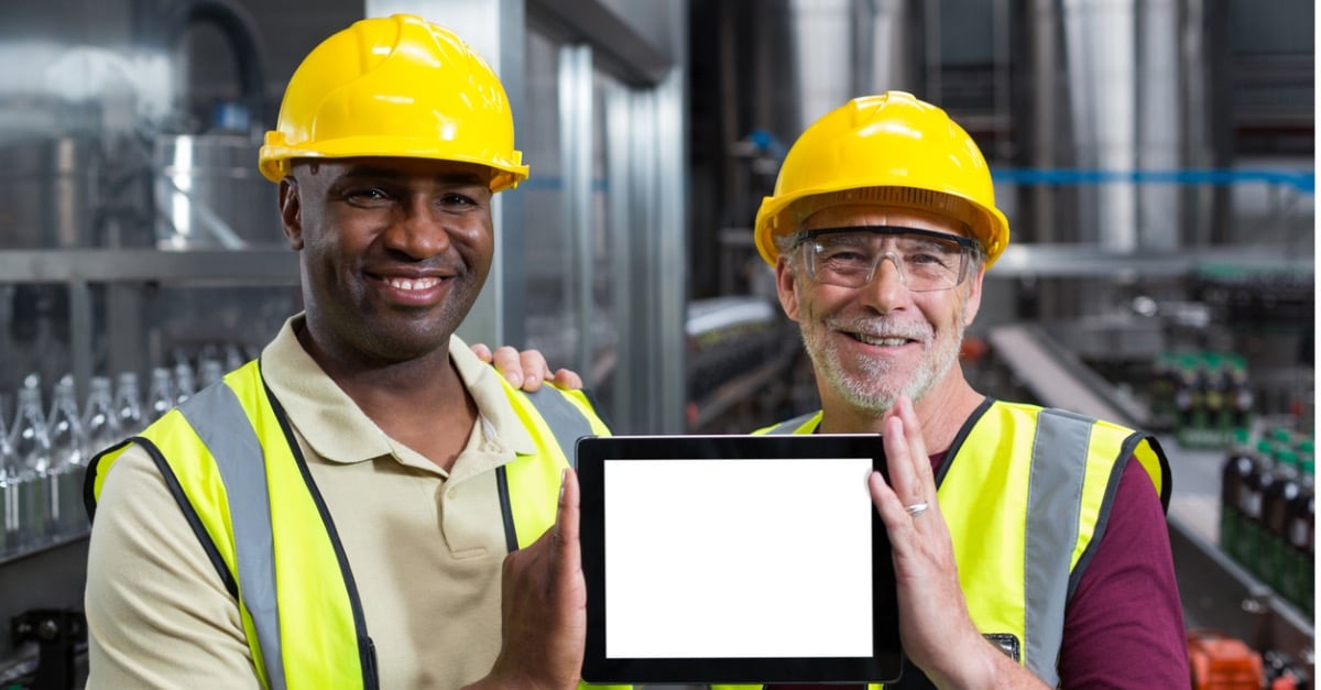 Portrait of two factory workers holding a digital tablet in the plant