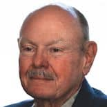 A close-up of an elderly man with a bald head and a mustache, wearing a dark suit jacket, shown against a white background, epitomizes the wisdom needed to use OEE effectively.